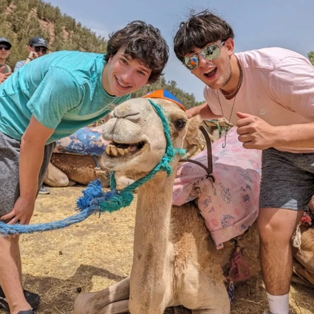 Jewish boys smiling with a camel at the Bedouin Tents.